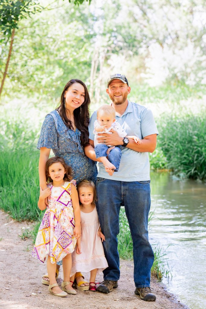 Mom, Dad, baby and two daughters pose by the creek for summer portraits.