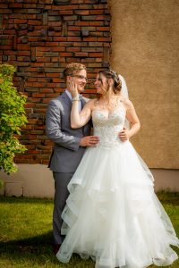 bride and groom outside brick wall