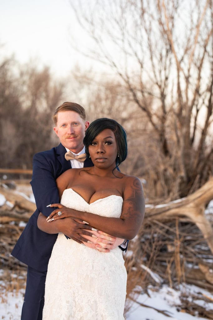 Wedding Photographer, bride and grroom hold each other on a snowy day