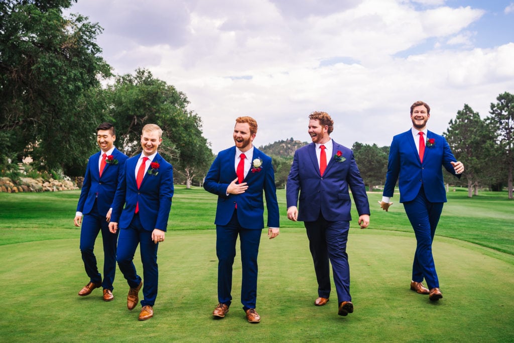 Wedding Photographer, Groomsmen walk together in grassy field