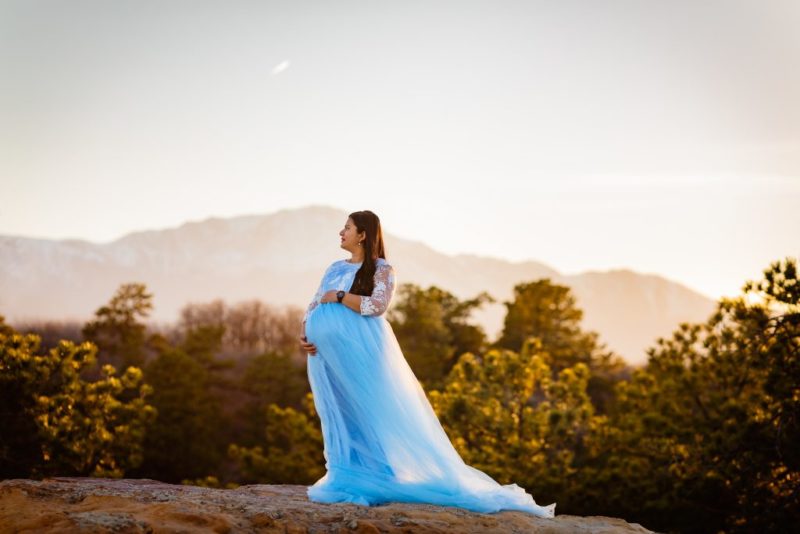 Maternity picture scheduled at sunset with mountains in the background with mom in a blue gown