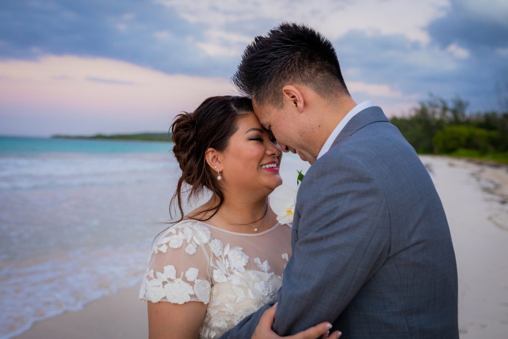 Wedding Photographer, bride and groom embrace on a beach