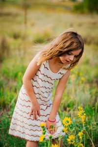 Colorado photo of girl looking at sunflowers
